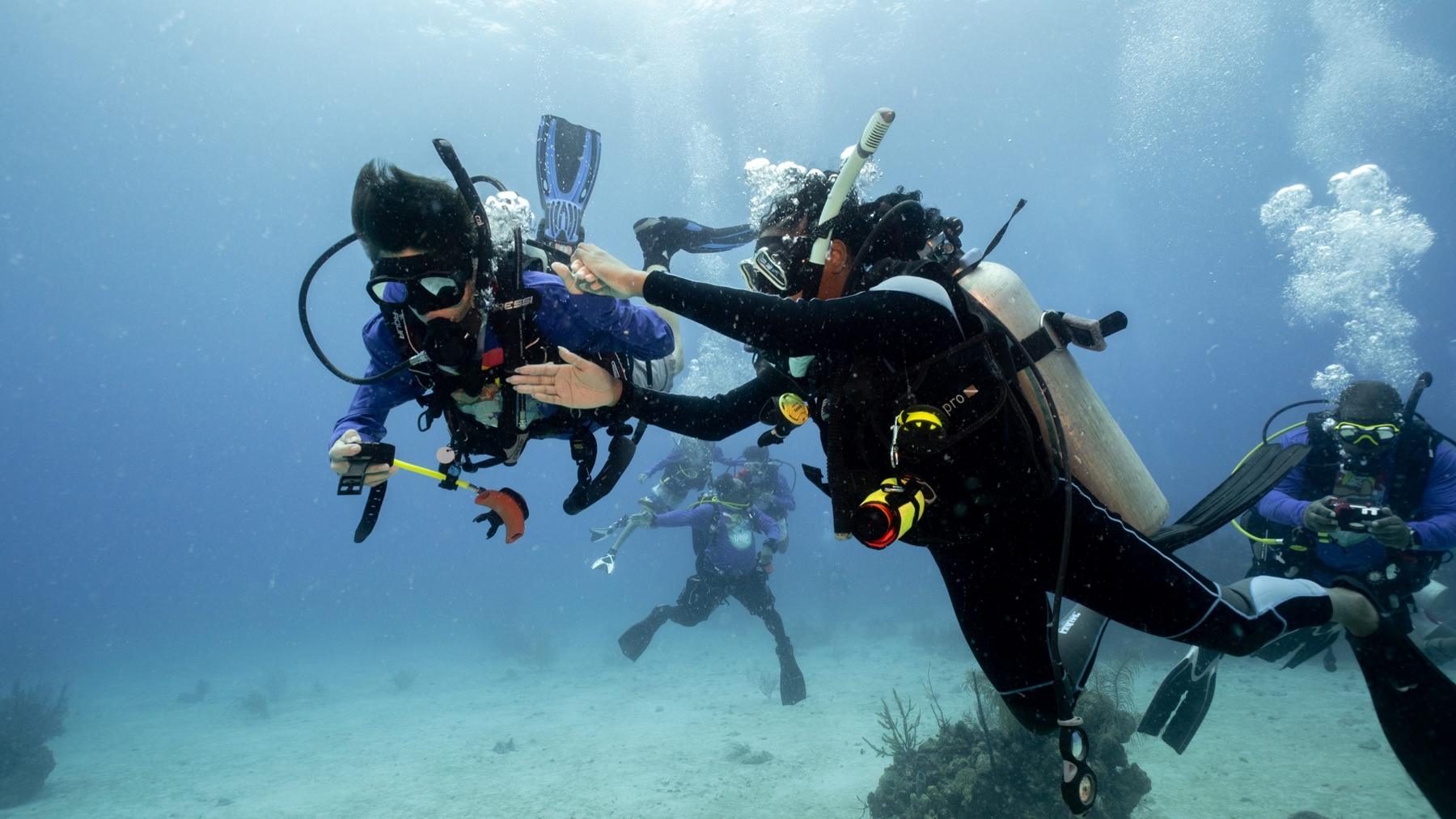 Youth conservation divers working together underwater